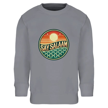 Say Salaam Sunset Glow Part-Recycled Cotton-Poly Kids Sweatshirt in Grey Melange, a heather grey marl tone also known as classic athletic grey blend. The vibrant circular sunset emblem stands out clearly against the textured neutral base. Crafted from an 80% cotton and 20% recycled polyester blend with brushed fleece lining for warmth. Ribbed cuffs and hem provide structure and durability for school, football and everyday modest outfits. A versatile unisex children’s sweatshirt.