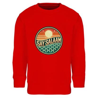Say Salaam Sunset Glow Part-Recycled Cotton-Poly Kids Sweatshirt in Bright Red, a powerful scarlet tone comparable to Rosso Corsa racing red. The retro sunset badge design blends warm sun hues and ocean wave graphics, creating strong contrast against the red base. Made from 80% cotton and 20% recycled polyester with brushed fleece lining for warmth and resilience. Ribbed trims enhance durability for football training, school and active play. A bold statement piece for confident modest kids streetwear.