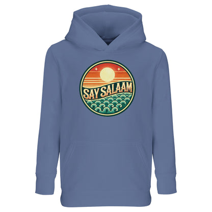 Say Salaam Sunset Glow Part-Recycled Cotton-Poly Kids Hoodie in Blue, a classic mid blue shade with subtle marble blue and blue-grey undertones. The circular Sunset Glow emblem contrasts strongly against the blue base, blending warm horizon colours and cool ocean wave graphics. Cotton and recycled polyester construction with brushed fleece lining ensures warmth and durability. A relaxed fit hoodie perfect for football fans and modest youth streetwear.