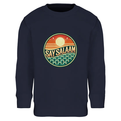 Say Salaam Sunset Glow Part-Recycled Cotton-Poly Kids Sweatshirt in French Navy, a deep navy shade close to ebony clay with midnight blue richness. The warm sunset badge stands out boldly against the dark base, highlighting layered orange sun tones and teal wave detailing. Constructed from cotton and recycled polyester with soft brushed fleece lining for warmth and durability. Ribbed trims maintain shape during active play, sport and school. A childrens jumper blending football culture and modest streetwear