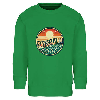Say Salaam Sunset Glow Part-Recycled Cotton-Poly Kids Sweatshirt in Kelly Green, a vibrant fresh green shade comparable to spring green with subtle eucalyptus undertones. The circular sunset logo pops vividly against the green background, combining retro coastal styling with modern Muslim streetwear identity. Made from an cotton and 20% recycled polyester blend, this brushed fleece children’s jumper offers warmth, durability and comfort. Ideal for football fans, school outfits and expressive everyday wear.
