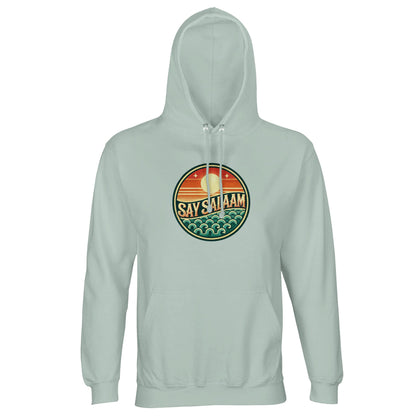 Say Salaam Sunset Glow Part-Recycled Unisex Cotton-Poly Hoodie in creamy green, a muted pastel green tone similar to eucalyptus with gentle spring green notes. The circular sunset badge pops against the soft base, highlighting warm dusk hues and stylised teal waves. Constructed from 80% cotton and 20% recycled polyester with brushed fleece lining and 280gsm structure. A relaxed unisex hoodie ideal for football culture and modest everyday styling.