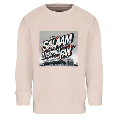 Say Salaam to the Liverpool Fan Design #2 Part-Recycled Cotton-Poly Kids Sweatshirt – Creamy Pink / Soft Rose featuring graffiti-style lettering in red, white, and gold, cutting through an Anfield sketch. Crafted from brushed cotton and recycled polyester, it’s comfortable, durable, and full of character. The delicate tone softens the street-art edge, perfect for young Liverpool fans celebrating faith, kindness, and community alongside their club’s enduring legacy.
