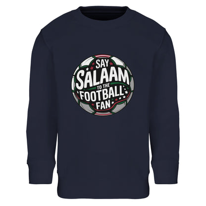 Say Salaam to the Football Fan Design #1 Part-Recycled Cotton-Poly Kids Sweatshirt – French Navy / Dark Navy. Islamic youth football sweatshirt with a bold circular football crest graphic across the chest. The round badge blends charcoal pitch textures, forest green highlights, bright white typography and light red detailing, framed by stadium glow beams. A strong symmetrical club-style shape delivers authentic matchday tone for young Muslim football fans.