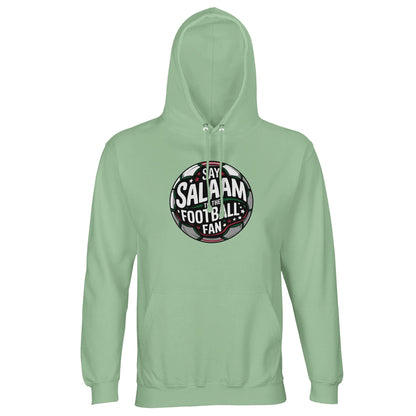 Frozen Green / Opal Islamic unisex hoodie featuring the Say Salaam to the Football Fan Design #1 circular badge print. The round football emblem combines dark charcoal pitch textures, green accents and white typography illuminated by stylised floodlights. The clean circular geometry and layered depth create a bold crest-inspired look with an authentic supporters’ vibe. Muslim football streetwear ideal for stadium attendance, youth leagues and Islamic community sports events.