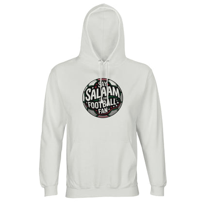 White / Platinum unisex hoodie featuring the Say Salaam to the Football Fan Design #1 circular badge graphic. The design has a bold round football crest shape with a dark charcoal and black base, stadium floodlight glow & layered typography wrapping the sphere. Crisp white and soft green accents create contrast on the clean light background, giving it a modern sporty tone. Muslim football streetwear blending Islamic identity with matchday culture, ideal for stadium visits, 5-a-side games & community events.
